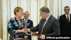 Armenia - The chief of the Armenian government staff, Davit Harutiunian (R), and Karen Hilliard, the USAID’s mission director for Armenia, sign an agreement in Yerevan, 5Feb2016.