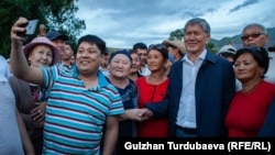 Almazbek Atambaev poses for a photo with supporters outside his compound in Koi-Tash on June 27.