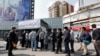People wait in line to receive packages for precautions against the coronavirus from a booth in Tehran on March 15.