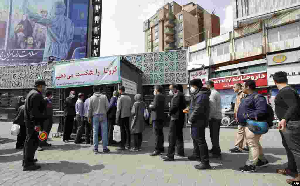 People wait in line in Tehran to receive packages for precautions against the spread of the disease. The goods were provided by the Basij, a militia loyal to Iran&#39;s Islamic rulers.