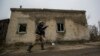 A Ukrainian soldier points toward the zone of combat in an industrial area near Avdiyivka, just north of Donetsk.&nbsp;