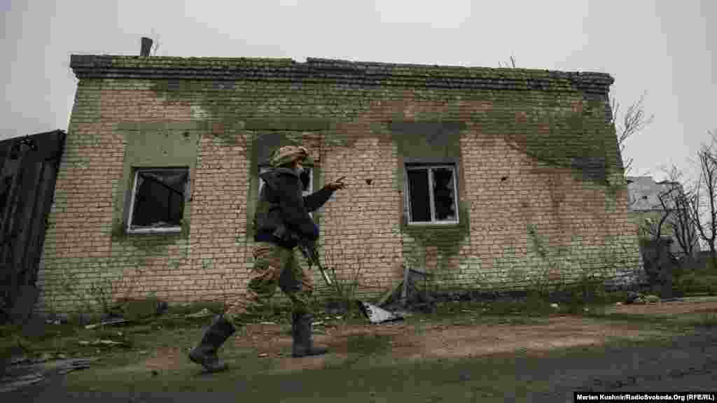 A Ukrainian soldier points toward the zone of combat in an industrial area near Avdiyivka, just north of Donetsk. 