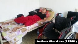 Жаслан Сулейменов на кровати рядом с инвалидным креслом. Астана, 9 февраля 2017 года.