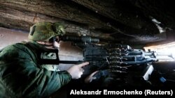 A fighter of the separatists based in Donetsk looks through a sight inside a dugout on the line of separation from the Ukrainian armed forces near the Staromykhailivka settlement on January 23.