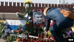 Ресейлік оппозициялық саясаткер Борис Немцов қаза тапқан жерге гүл қойып жатқан әйел. Мәскеу, 9 наурыз 2015 жыл.