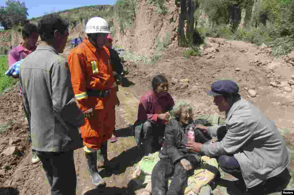 A man offers water to a woman injured in the quake.