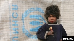 An Afghan girl waits while her mother receives food aid from the UNHCR in Kabul earlier this month.