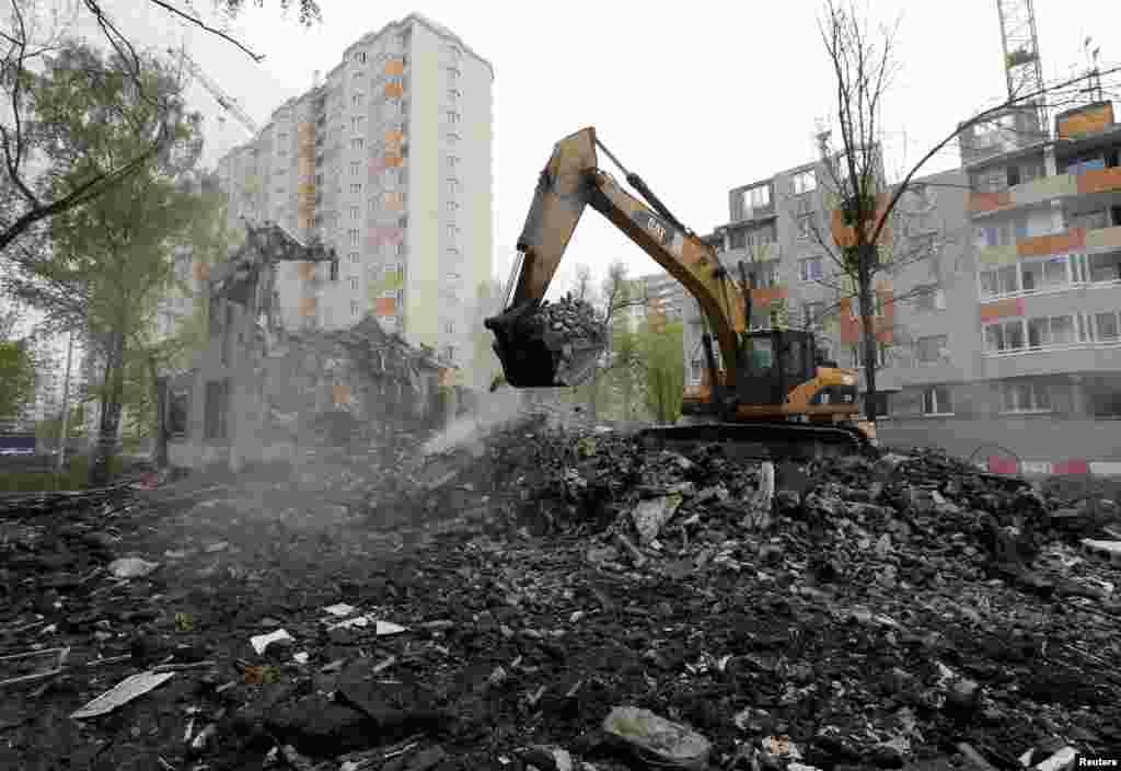A digger scoops up what remains of a Soviet-era apartment block on May 16.