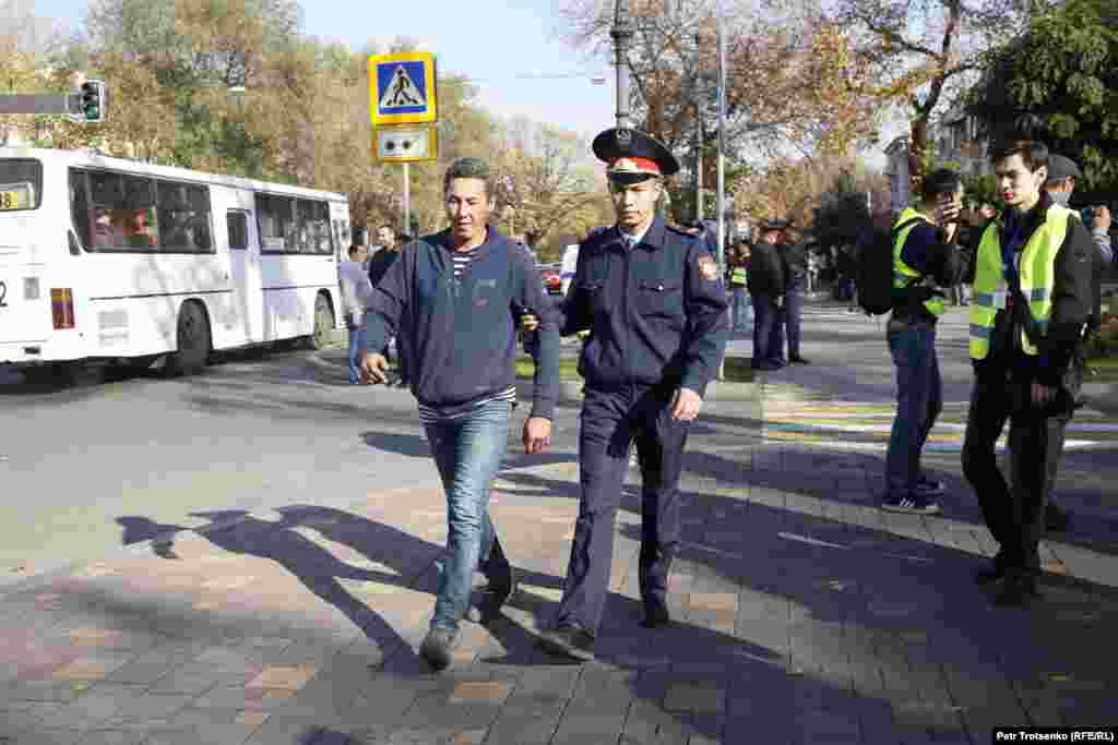 В этот день в Алматы были задержаны десятки людей. На фото полицейские ведут мужчину в автозак.