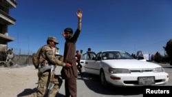 An Afghan policeman inspects passengers at a checkpoint on the outskirts of Jalalabad, capital of Nangarhar province on April 29.