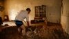 IRAN -- A man clears away mud from his house following floods in the Iranian city of Mamulan in Lorestan province, April 7, 2019