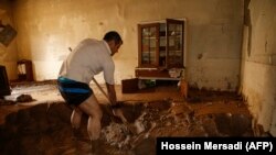 IRAN -- A man clears away mud from his house following floods in the Iranian city of Mamulan in Lorestan province, April 7, 2019