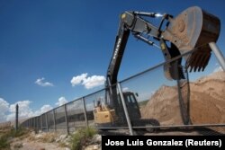 Екскаватор зносить паркан, замість якого буде зведено стіну на кордоні США з Мексикою. Санленд-Парк, США, серпень 2016 року
