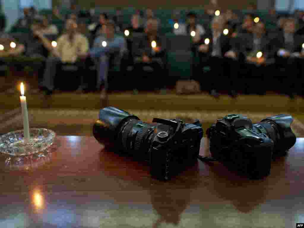 A light burns next to two cameras posed symbolicallly during a memorial service for slain photojournalists Tim Hetherington and Chris Hondros held in Benghazi on April 21. Fellow media workers, diplomats, local rebel officials and relief workers paid homage to the pair, who were killed by a mortar strike in the besieged western Libyan city of Misurata on April 20.Photo by Odd Andersen for AFP