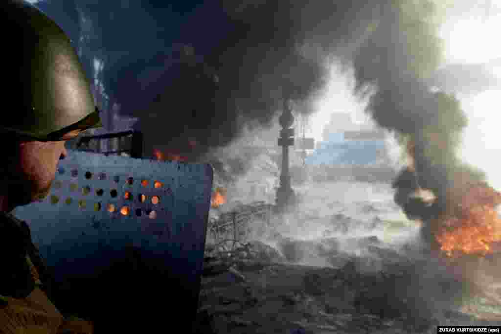 A protester stands on the barricade during an anti-government protest in downtown Kyiv, Ukraine, 25 January 2014.
