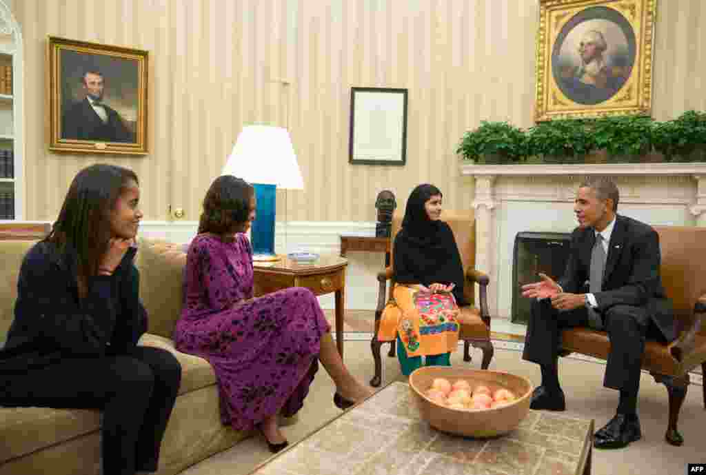 U.S. President Barack Obama, Michelle Obama, and their daughter Malia (left) meet with Yousafzai in the Oval Office in Washington on October 11, 2013.