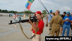 Девочка из движения «Юнармия» прицеливается из снайперской винтовки на праздновании Дня ВДВ в Севастополе, август 2019 года