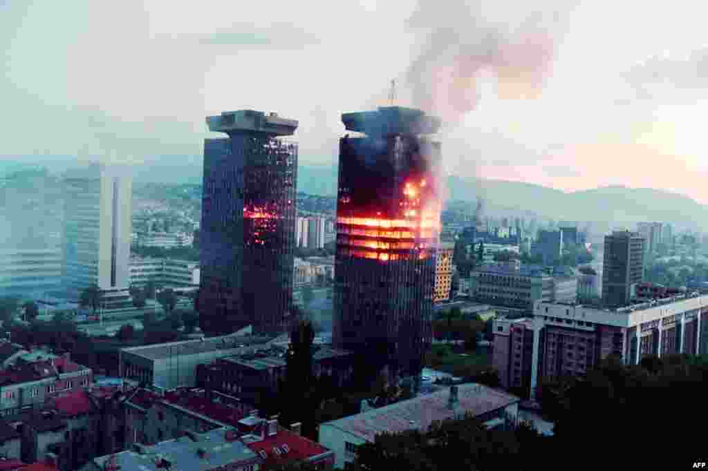 The UNIS twin towers burn along &#39;Sniper Alley&#39; in downtown Sarajevo as heavy shelling and fighting raged in the Bosnian capital on June 08, 1992. &nbsp;Nicknamed &#39;Momo&#39; and &#39;Uzeir&#39; after a popular ethnic Bosniak and Serb comedy duo, the structures were heavily damaged during the siege of Sarajevo but remained standing to became a symbol of the city&#39;s resilience.