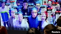 Люди дивляться на екран, що демонструє технологію розпізнавання обличчя на виставці Digital China у Фучжоу, провінція Фуцзянь, Китай 8 травня 2019 року