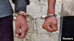 Afghanistan -- Two young boys are handcuffed at a local liquor factory in Kabul, 29Jun2010