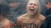 Активистка FEMEN протестует против визита Путина в Брюссель (надпись на груди девушки: "Путин – убийца демократии"), 28 января 2014 года