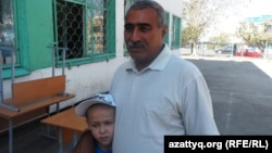 Житель Шымкента Сагынбай Алиев с сыном-второклассником, который учится в школе-лицее № 46. 27 августа 2014 года.