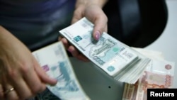 Russia -- An employee of a bank counts ruble banknotes in Moscow, September 2, 2014