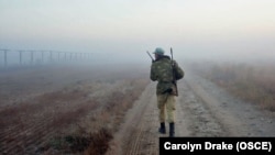 На фотографии (дата неизвестна) полицейский патрулирует вдоль афгано-таджикской границы