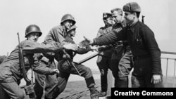 U.S. and Soviet soldiers greet each other on the Elbe in Germany on April 25, 1945.