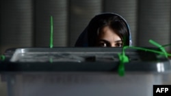 An Afghan election commission worker awaits the opening of ballot-box seals for an audit of the presidential runoff vote at a counting center in Kabul on July 17.