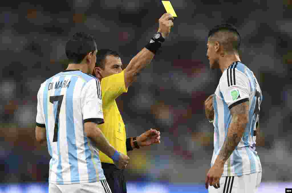 Sudija Joel Aguilar daje žuti karton argentinskom igraču Marcosu Roji