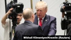 U.S. President Donald Trump (facing) greets Russian President Vladimir Putin in Danang, Vietnam, on November 11.