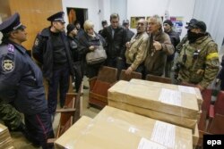 Ukrainian activists block the printing of election ballots at a printing press in Mariupol on October 19. Some fear Ukraine's richest oligarch will manipulate the vote.