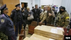 Ukrainian activists block the printing of election ballots at a printing press in Mariupol on October 19. Some fear Ukraine's richest oligarch will manipulate the vote.
