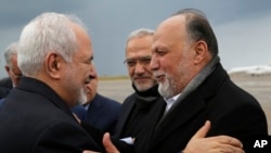 Iran's Foreign Minister Mohammad Javad Zarif, left, greets by Lebanese Hezbollah lawmaker, Ali Ammar, upon his arrival at Rafik Hariri Airport, in Beirut, Lebanon, Sunday, Feb. 10, 2019. Zarif said his country is ready to cooperate with the new Lebanese g