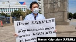 Азаматтық белсенді, журналист Жанболат Мамай Тәуелсіздік ескерткіші жанында жалғыз адам пикетін өткізіп тұр. Алматы, 6 шілде 2020 жыл.