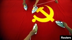 Drapelul partidului comunist al Chinei, la o fabrică din Beijing care produce 30.000 de steaguri pe lună. (Foto: REUTERS/David Gray)