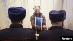 Russian photographer Denis Sinyakov stands in the dock during a court session in St. Petersburg on November 18, at which his bail was set at around $61,000.