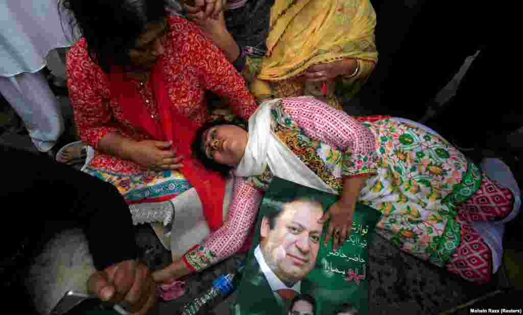 A supporter of Pakistan's former prime minister, Nawaz Sharif, passes out after the Supreme Court's decision to disqualify him from office, in Lahore. (Reuters/Mohsin Raza)