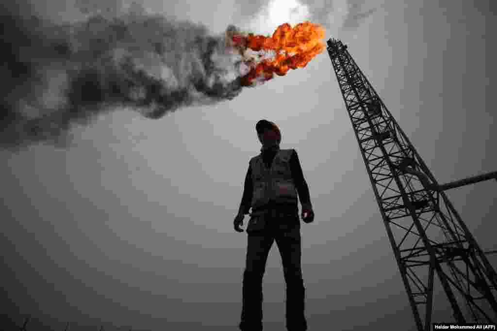 An employee stands amid the Zubair oil and gas field, north of the southern Iraqi province of Basra. (AFP/Haidar Mohammed Ali)