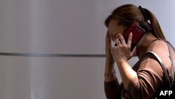 A woman talks on phone at a reception center for families and friends after an airliner went missing at the Kuala Lumpur International Airport on March 8.