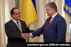 Ukrainian President Petro Poroshenko (right) presents former French President Francois Hollande with the Order of Freedom, a high state award, during their meeting in Kyiv on October 1.