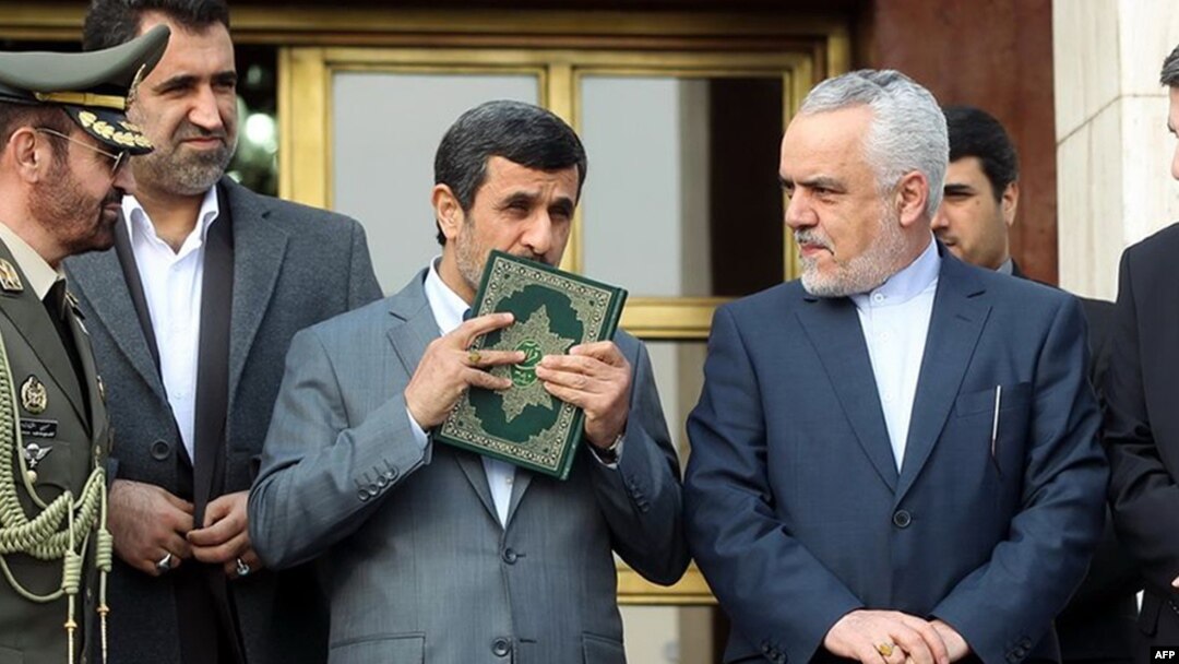 Mahmud Ahmadinejad kisses a copy of The Koran before leaving for a foreign visit in March 2013.