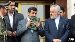 Mahmud Ahmadinejad kisses a copy of The Koran before leaving for a foreign visit in March 2013.