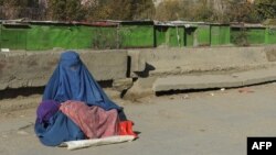 آرشیف - یک خانم در گوشه‌ای از شهر کابل از شدت فقر و ناداری دست به گدایی زده است.