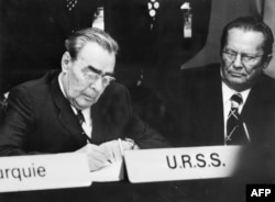 Леонид Брежнев подписывает Хельсинкский акт. Справа - лидер социалистической Югославии Иосип Броз Тито