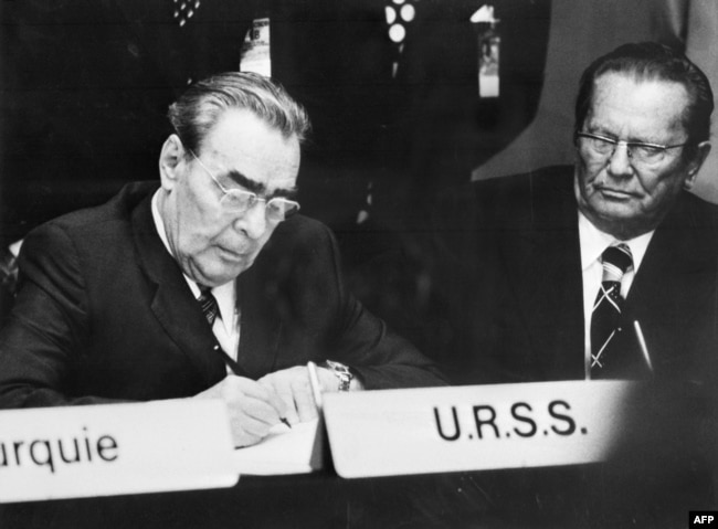 Леонид Брежнев подписывает Хельсинкский акт. Справа - лидер социалистической Югославии Иосип Броз Тито