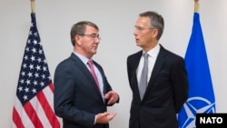 NATO Secretary-General Jens Stoltenberg (right) speaks with U.S. Defense Secretary Ash Carter at the start of a NATO defense ministers meeting in Brussels on October 8.