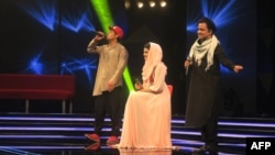 Afghan singer Zulala Hashemi, center, performs alongside competitors Sayed Jamal Mubarez, left, and Babak Mohammadi, right, during the TV music competition Afghan Star in Kabul on March 9