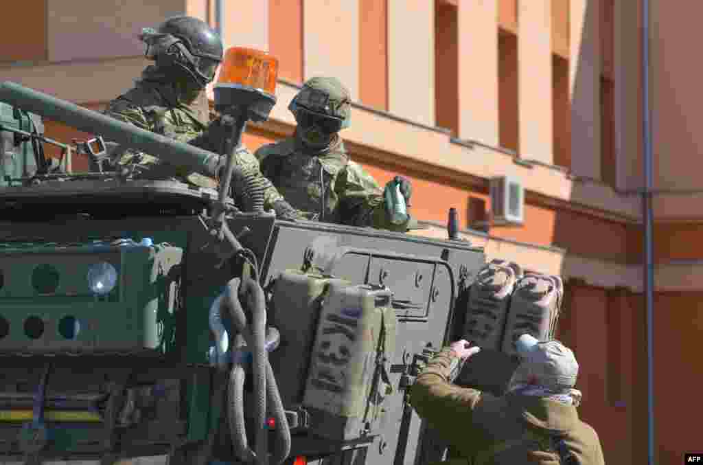 A man offers the soldiers a can of beer.